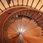 top down view of forged iron spiral staircase with solid wood red oak treads and handrail